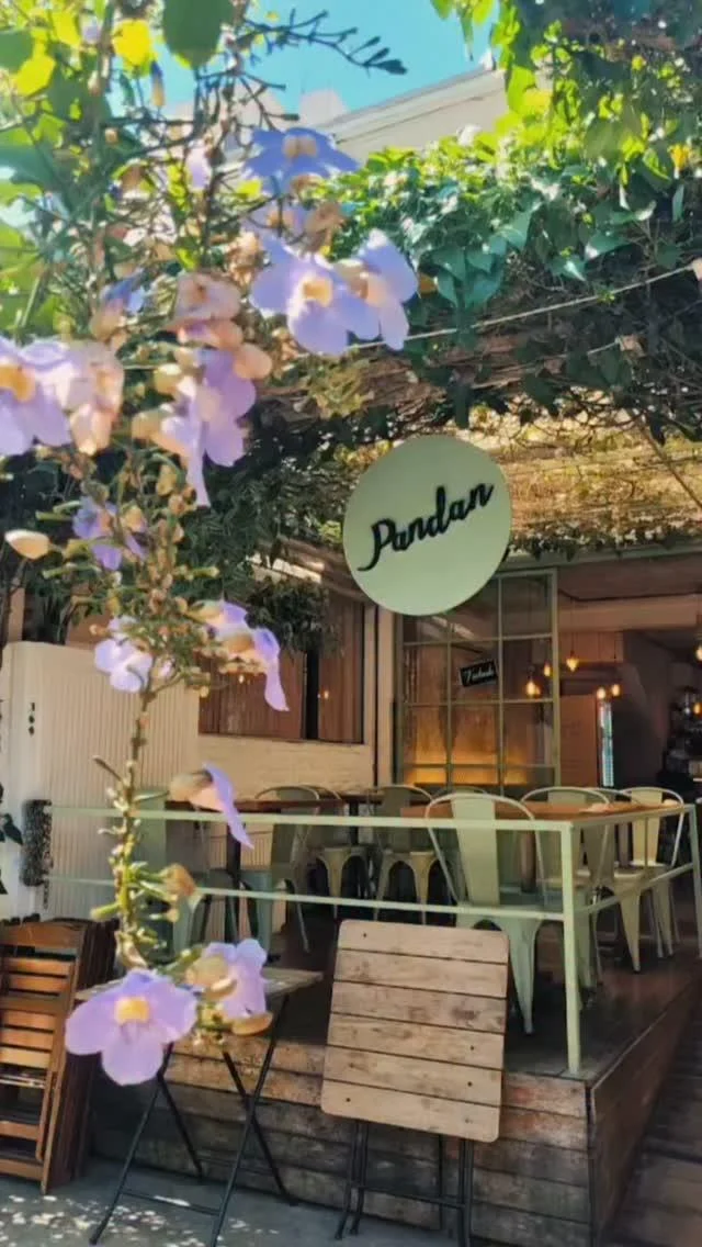 Fachada real da Pandan entre plantas, com o letreiro da casa em Pinheiros
